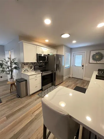 a kitchen with stainless steel appliances kitchen island granite countertop a stove and a refrigerator
