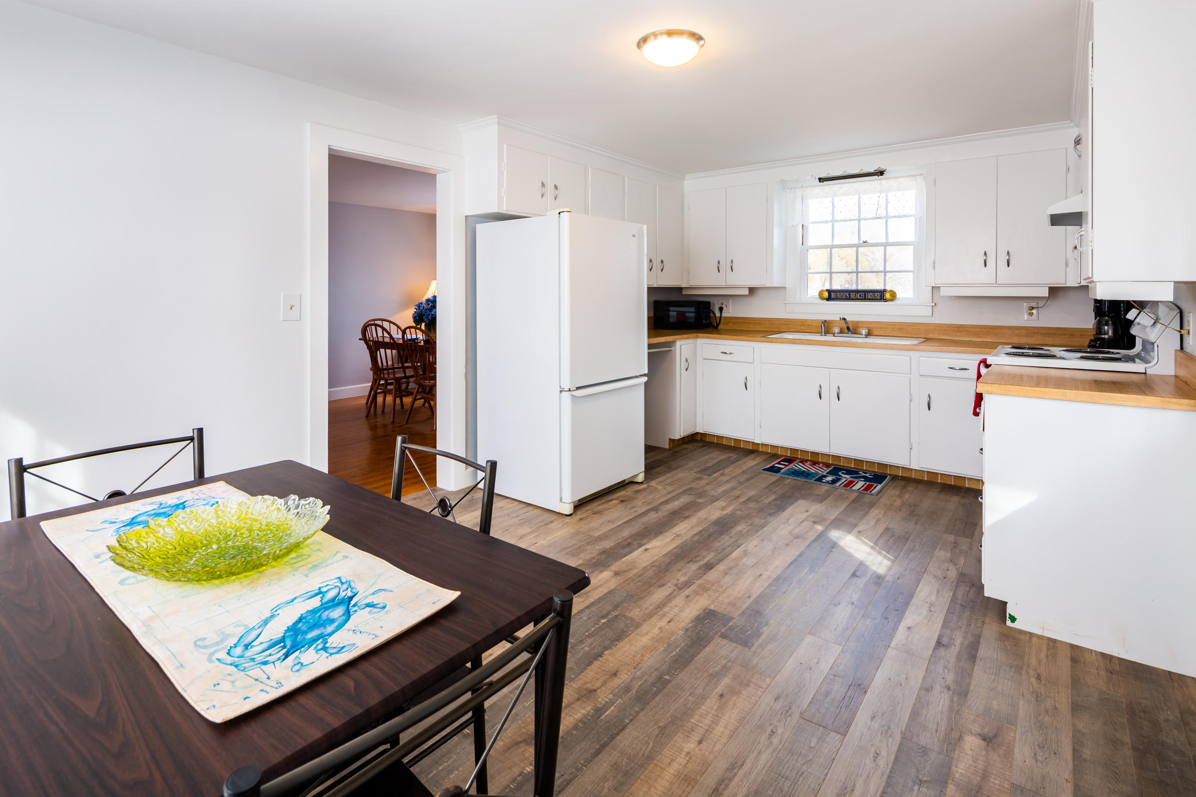 700 Main Street Cotuit, MA 02635 - Photo 7 of 20 a kitchen with stainless steel appliances granite countertop a refrigerator a stove a sink dishwasher and white countertops with wooden floor