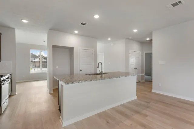a large white kitchen with a sink and dishwasher