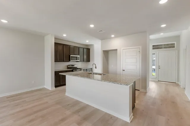 a view of a kitchen with a sink stove and cabinets