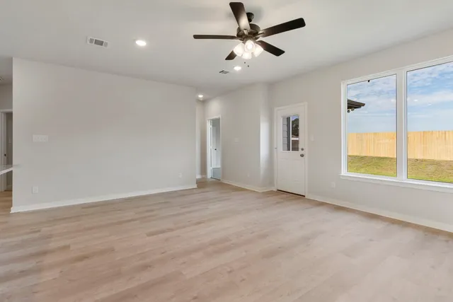 a view of a livingroom with a ceiling fan and window