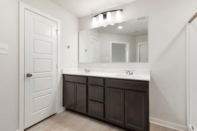 a bathroom with a double vanity sink and a mirror
