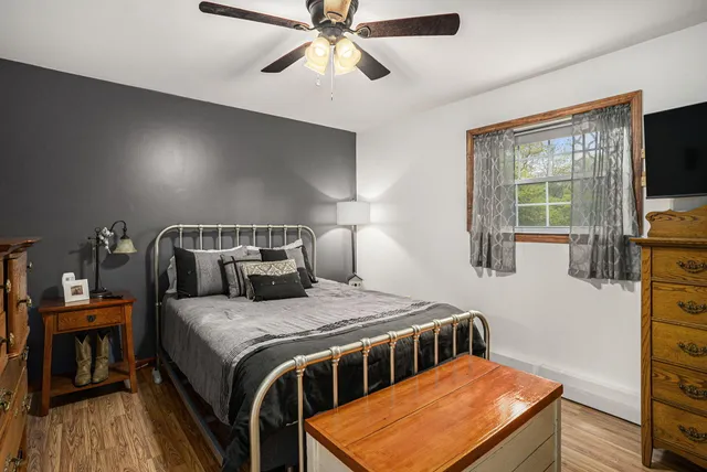 a bedroom with a bed and a flat tv screen on dresser