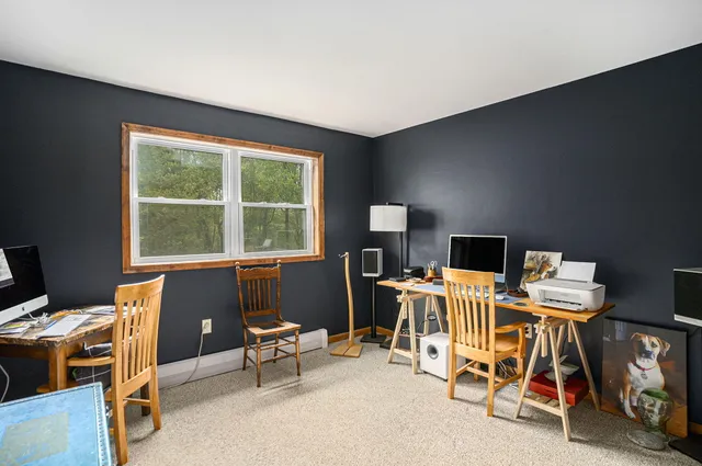 a view of a workspace with furniture and a window