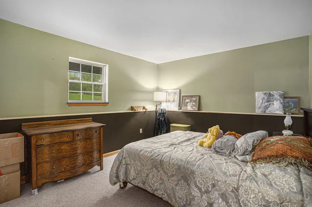 a bed sitting in a bedroom next to a window