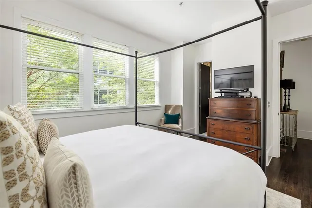 a spacious bedroom with a bed and a dresser next to a window