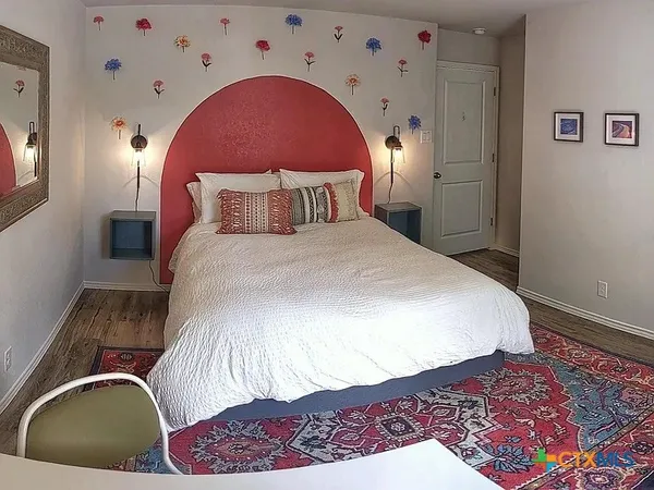 a bedroom with a bed and a painting on the wall