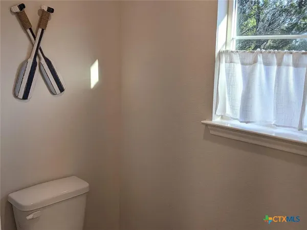 a bathroom with a toilet and a window