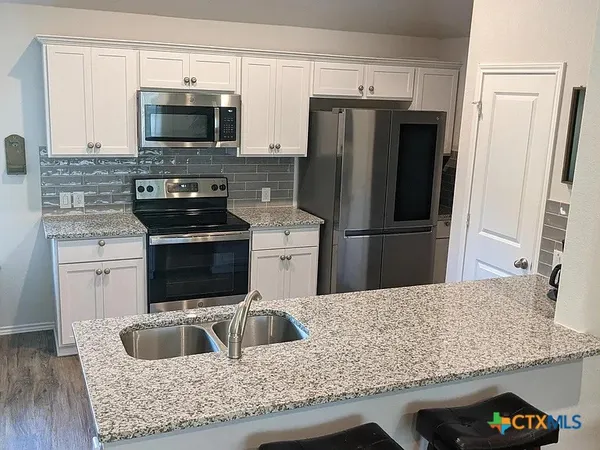 a kitchen with kitchen island a refrigerator sink and stove