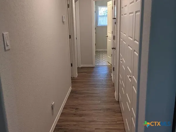 a view of a hallway with wooden floor and staircase
