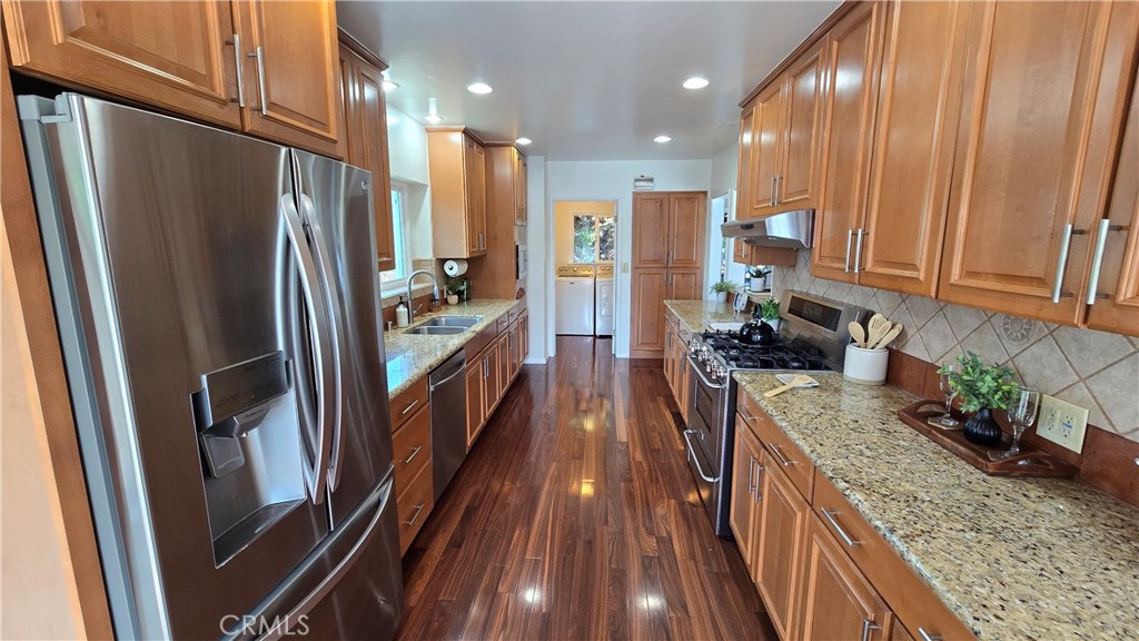 1111 Arbor Dell Road Los Angeles, CA 90041 - Photo 13 of 42 a kitchen with stainless steel appliances granite countertop refrigerator a sink and wooden cabinets