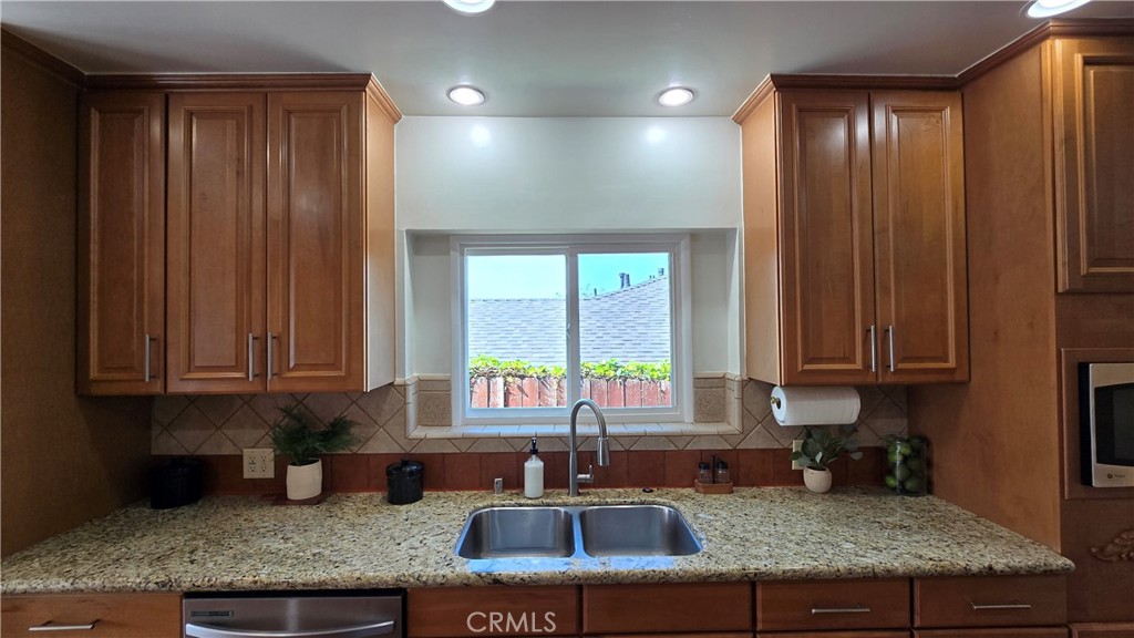 1111 Arbor Dell Road Los Angeles, CA 90041 - Photo 15 of 42 a kitchen with granite countertop wooden cabinets a sink and a window