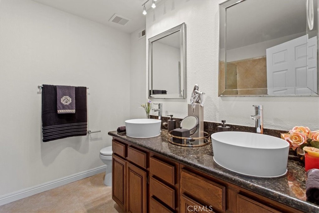 7230 Kelvin Avenue, Unit 6 Winnetka, CA 91306 - Photo 10 of 12 a bathroom with a granite countertop sink and a mirror