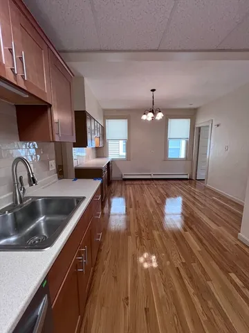 a kitchen with a sink and wooden floor