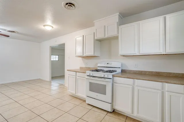 a kitchen with white cabinets and white appliances