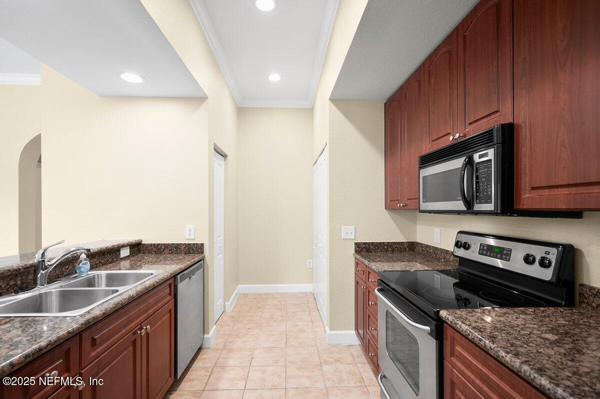 9745 Touchton Road, Unit 2421 Jacksonville, FL 32246 - Photo 7 of 26 a kitchen with granite countertop a sink and a stove top oven
