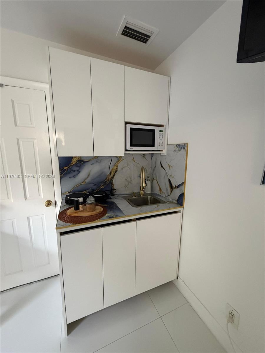 45 Southwest 28th Road Miami, FL 33129 - Photo 4 of 16 a kitchen with granite countertop white cabinets and a stove