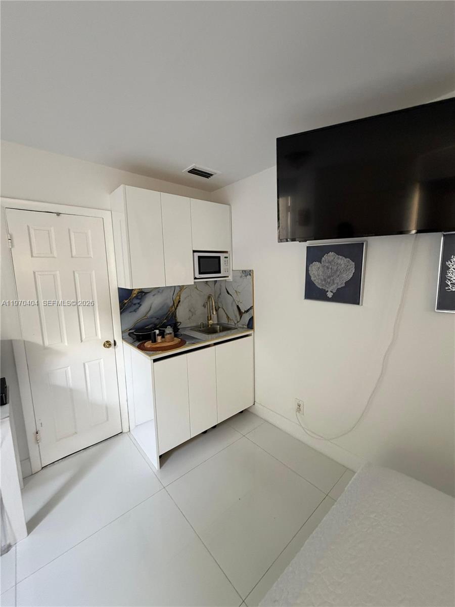 45 Southwest 28th Road Miami, FL 33129 - Photo 10 of 16 a kitchen with a sink and a stove top oven