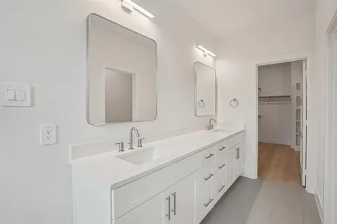 a bathroom with a double vanity sink mirror and