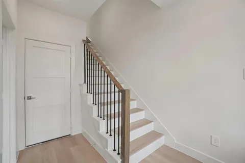 a view of staircase with railing and white walls