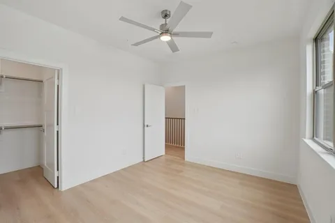 an empty room with fan and windows