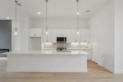 a view of kitchen with stainless steel appliances granite countertop cabinets and wooden floor