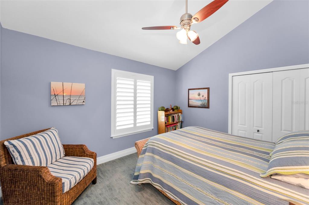13303 Gulf Lane Madeira Beach, FL 33708 - Photo 26 of 42 a bedroom with a bed and a chandelier