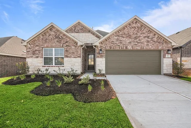 a front view of a house with a garden and yard
