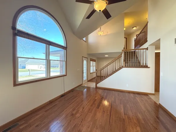 an empty room with wooden floor and windows