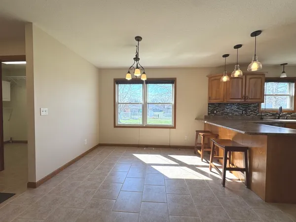 an empty room with windows and a chandelier fan