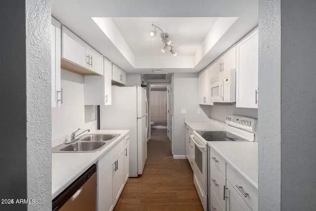 a kitchen with stainless steel appliances granite countertop a sink and a refrigerator