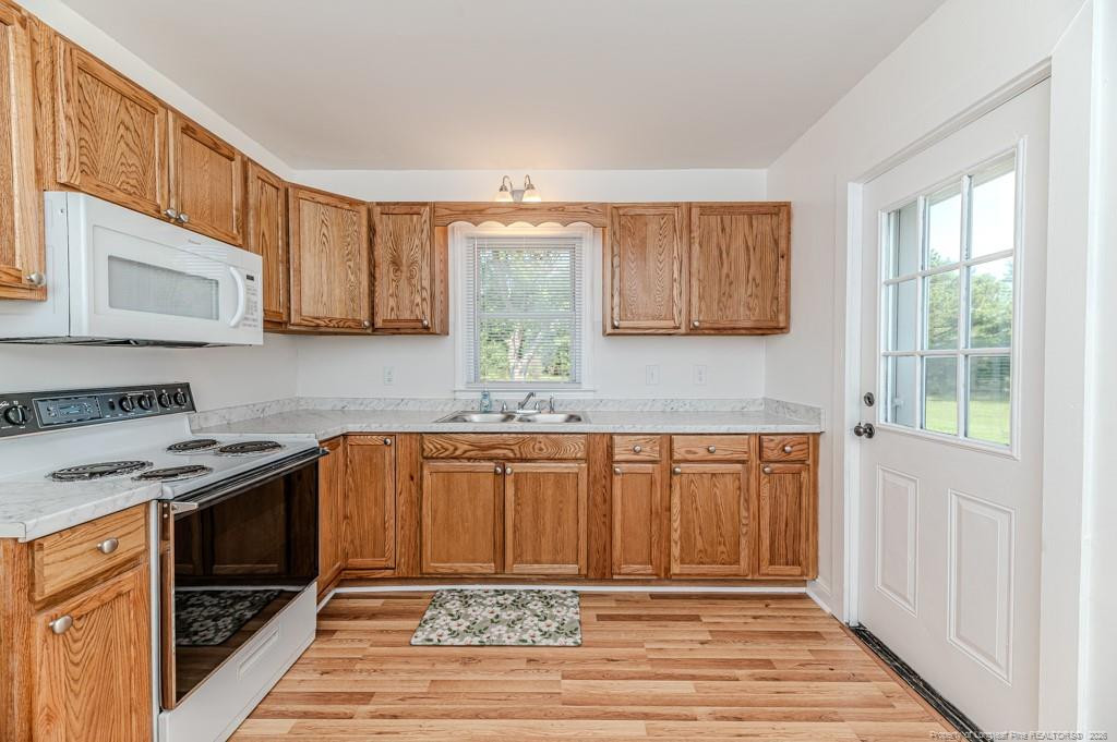 222 St Andrews Church Road Sanford, NC 27332 - Photo 13 of 24 a kitchen with stainless steel appliances granite countertop a stove a sink and a microwave