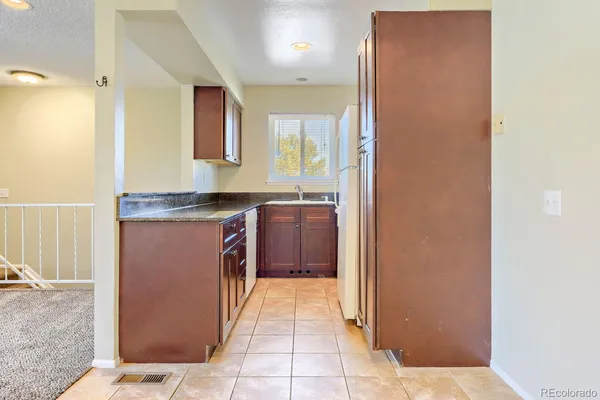 a kitchen with stainless steel appliances granite countertop a sink and a refrigerator