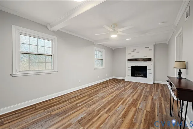 a view of empty room with wooden floor and fireplace