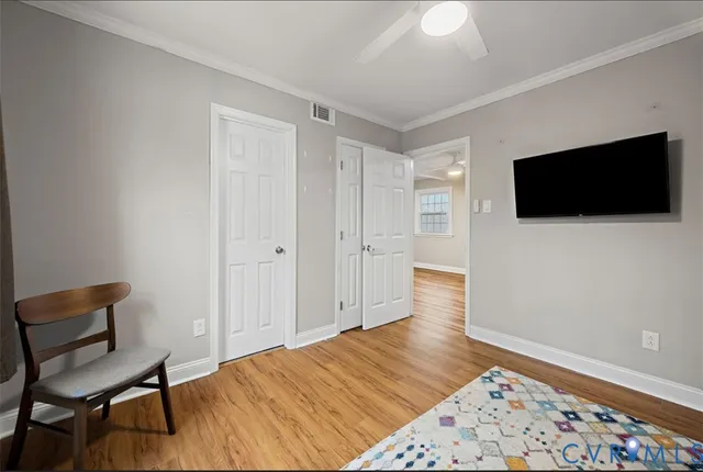 a view of a livingroom with wooden floor and a flat screen tv