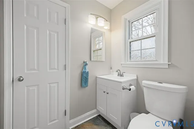 a bathroom with a sink a toilet and window