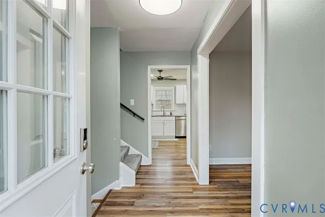 a view of a hallway with wooden floor and staircase