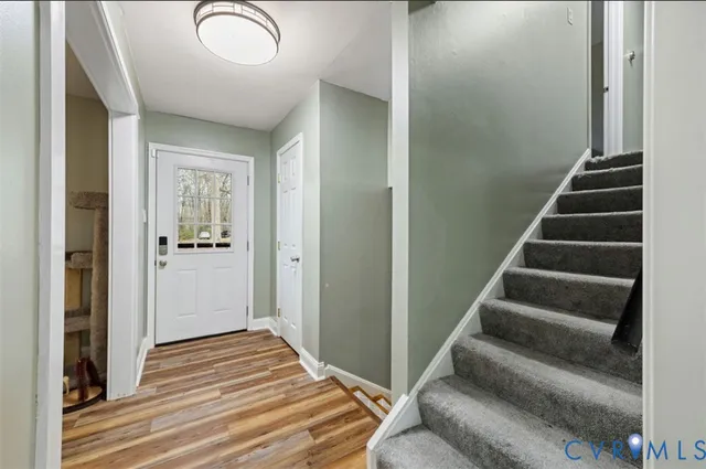 a view of a hallway with wooden floor and entryway