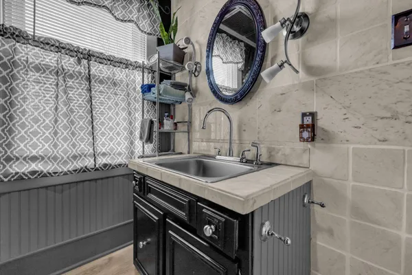 a bathroom with a sink a mirror and a table