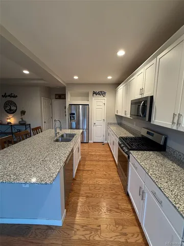 a kitchen with a sink a stove and a wooden floor