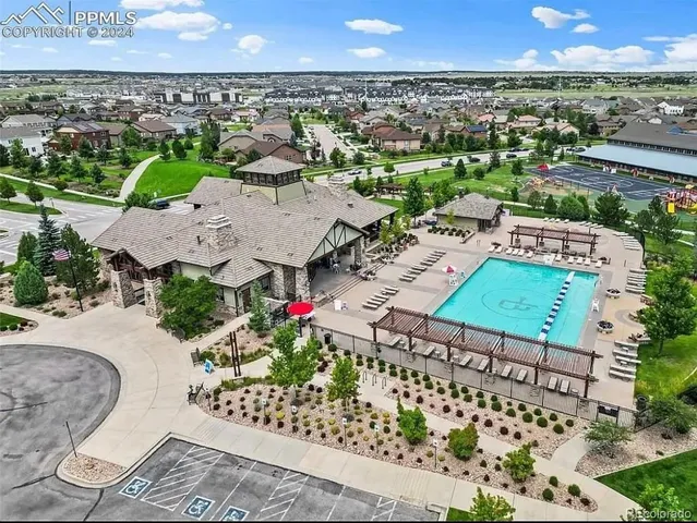a living room with furniture large windows and wooden floor
