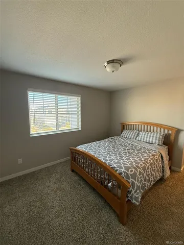 a bed sitting in a bedroom next to a window