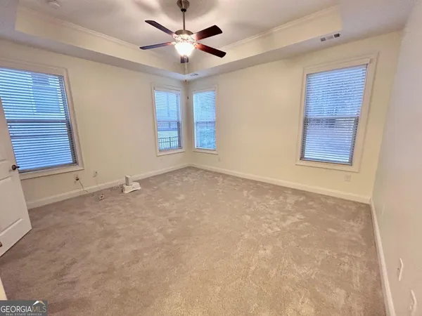 an empty room with windows and fan