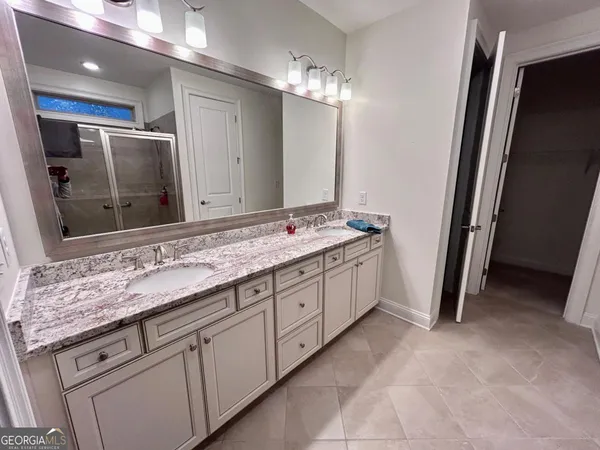 a spacious bathroom with a granite countertop sink and a mirror
