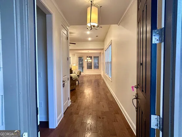 a view of a hallway with wooden floor and staircase