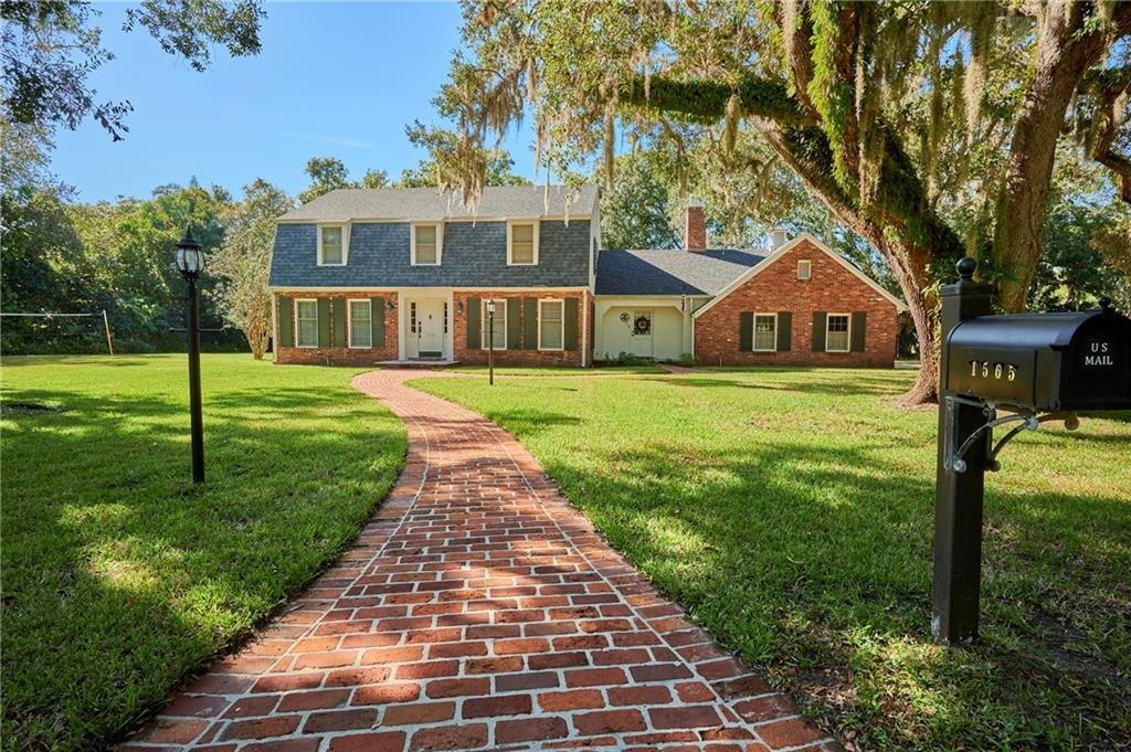 1565 48th Avenue Vero Beach, FL 32966 - Photo 1 of 34 a front view of a house with a yard