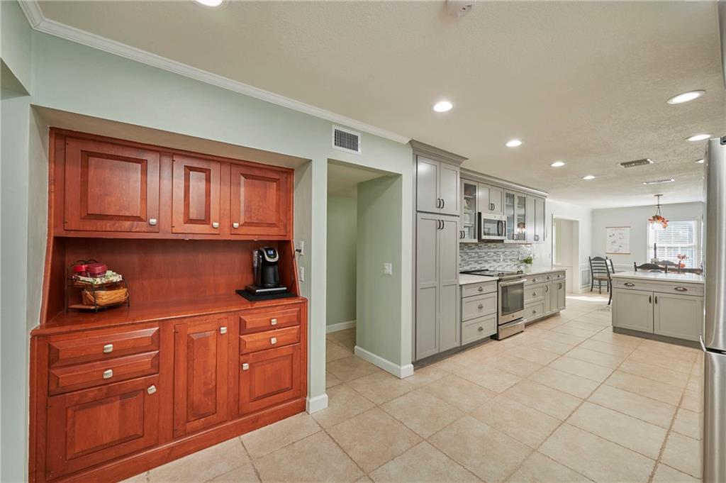 1565 48th Avenue Vero Beach, FL 32966 - Photo 11 of 34 a kitchen with stainless steel appliances granite countertop a refrigerator and cabinets