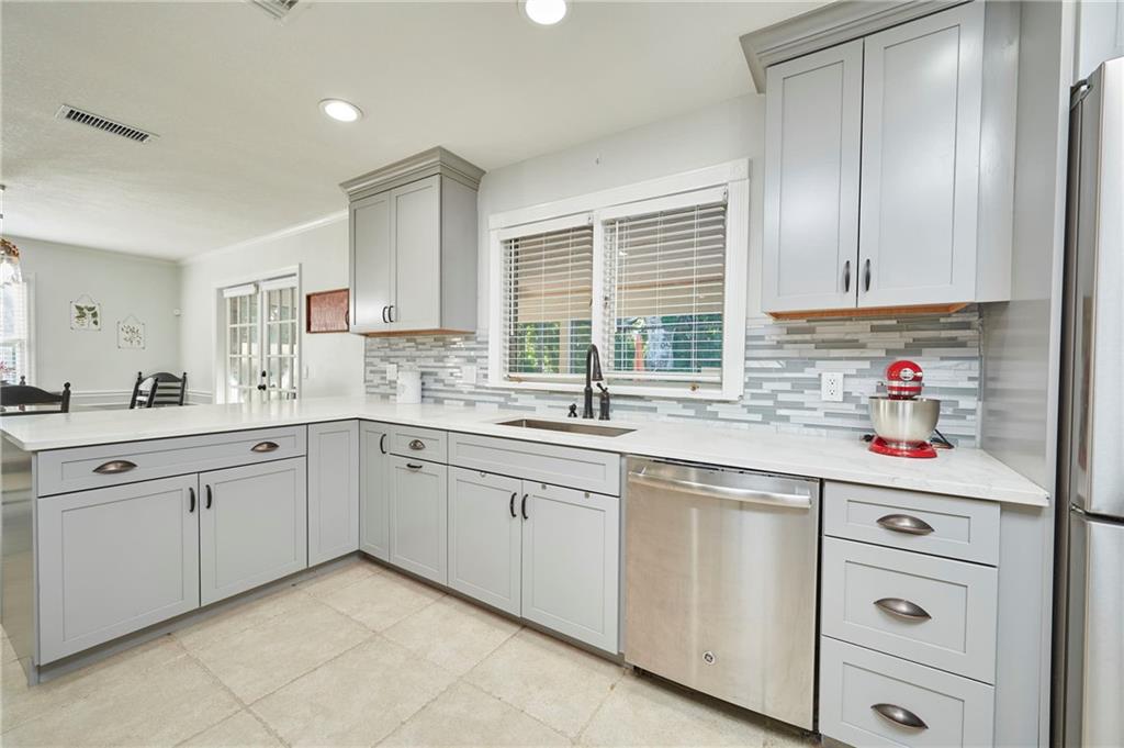 1565 48th Avenue Vero Beach, FL 32966 - Photo 13 of 34 a kitchen with cabinets appliances a sink and a window