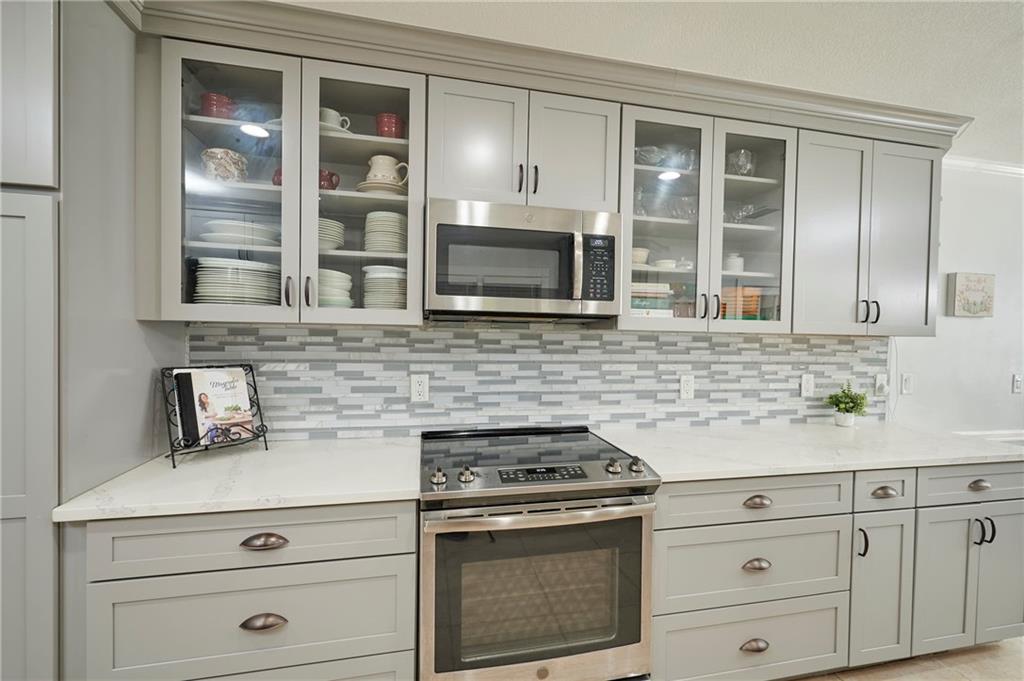 1565 48th Avenue Vero Beach, FL 32966 - Photo 15 of 34 a kitchen with granite countertop white cabinets stainless steel appliances and a sink