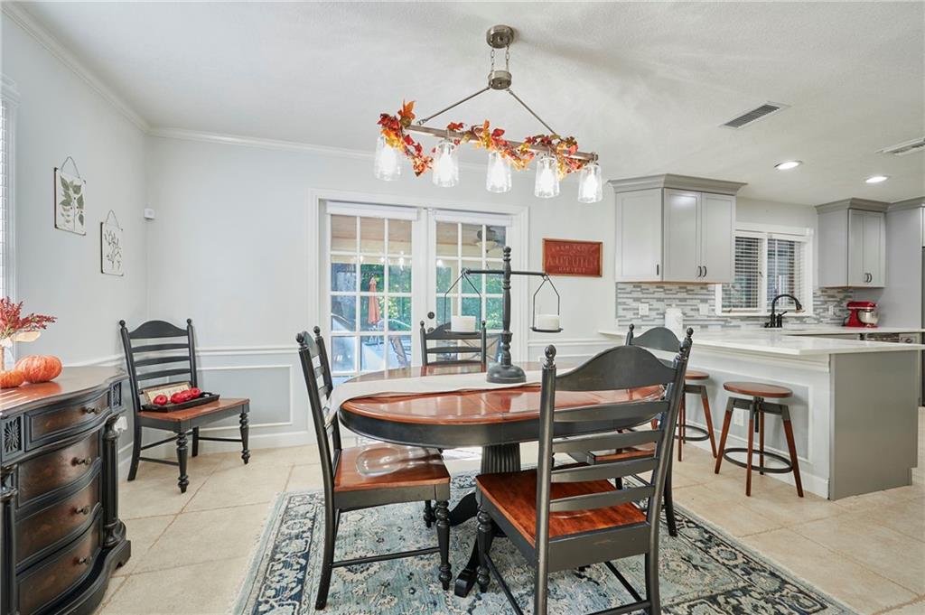 1565 48th Avenue Vero Beach, FL 32966 - Photo 17 of 34 a dining room with furniture a rug and a chandelier